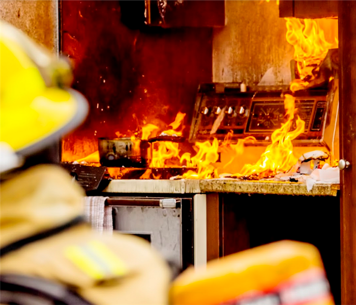 a fireman looking into a house with a stove on fire